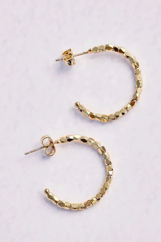 Gold hoop earrings on a light gray background