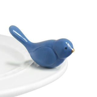 Blue ceramic bird figurine on a white plate