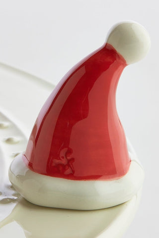 Red and white ceramic Santa hat on a white background