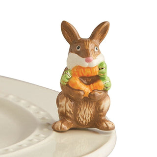 Decorative rabbit figurine holding a candy corn on a white plate