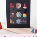 Black display case with decorative items on a white background