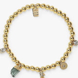 Gold beaded bracelet with charms on a white background