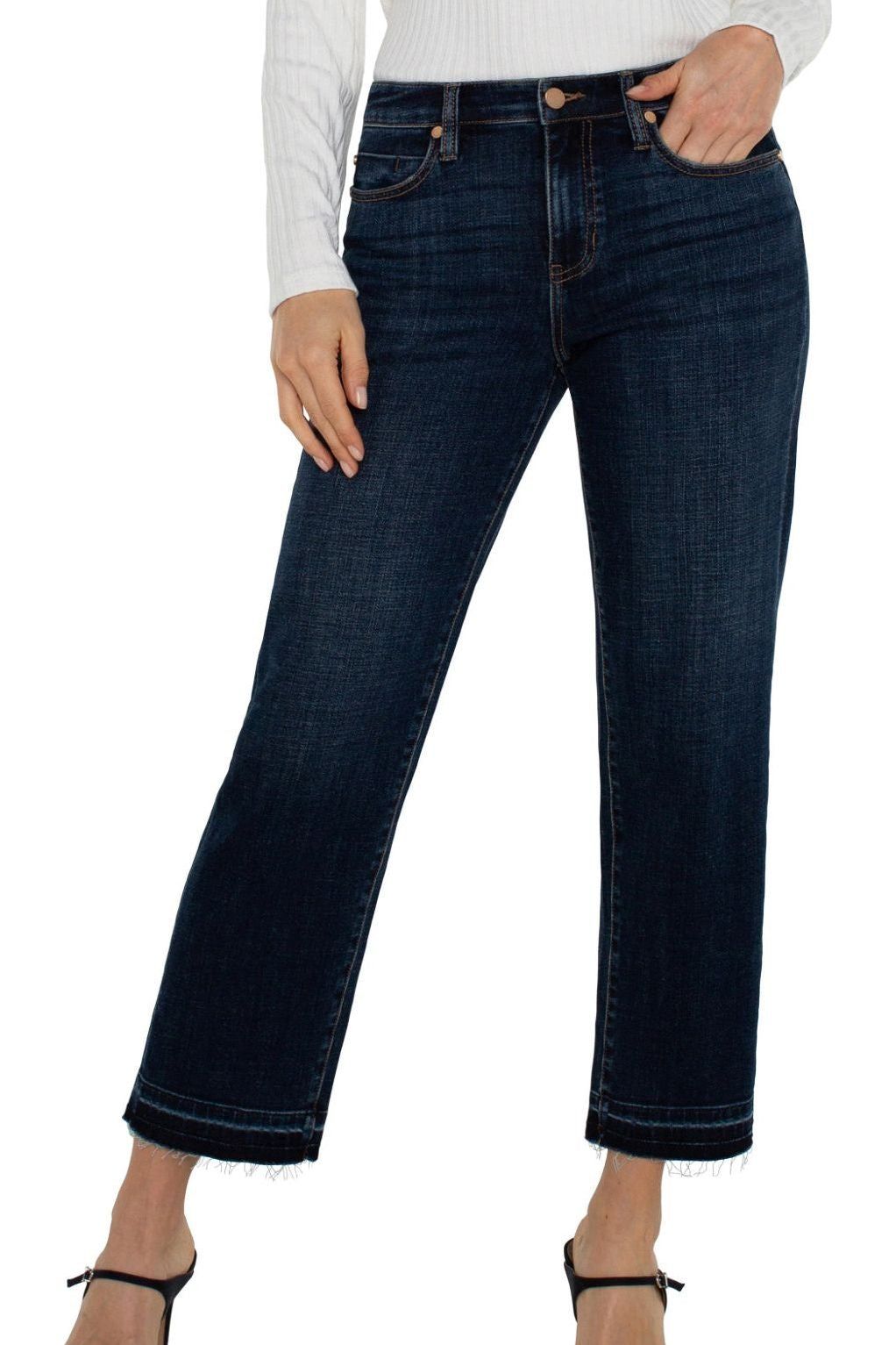 Dark blue jeans worn by a person on a white background
