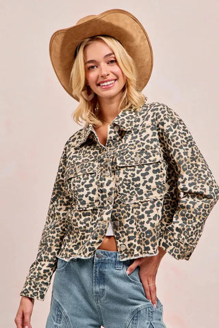 Woman wearing a leopard print jacket and wide-brimmed hat on a plain background