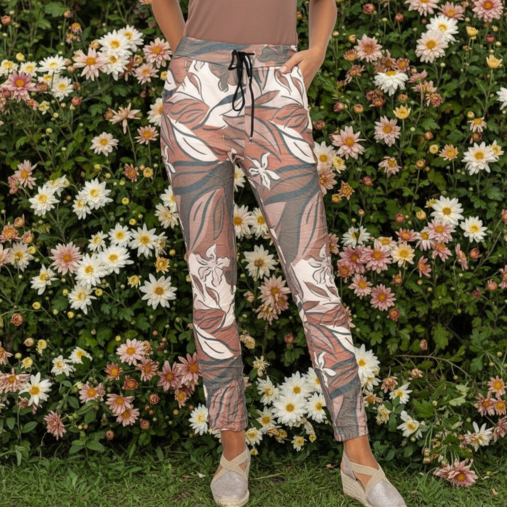 Floral patterned pants worn by a person on a white background