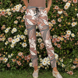 Floral patterned pants worn by a person on a white background