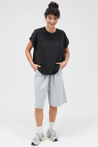 Person wearing a black t-shirt and gray shorts on a white background