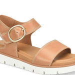Tan sandal with a gold buckle on a white background