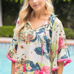 Woman wearing a floral kimono-style top by a pool