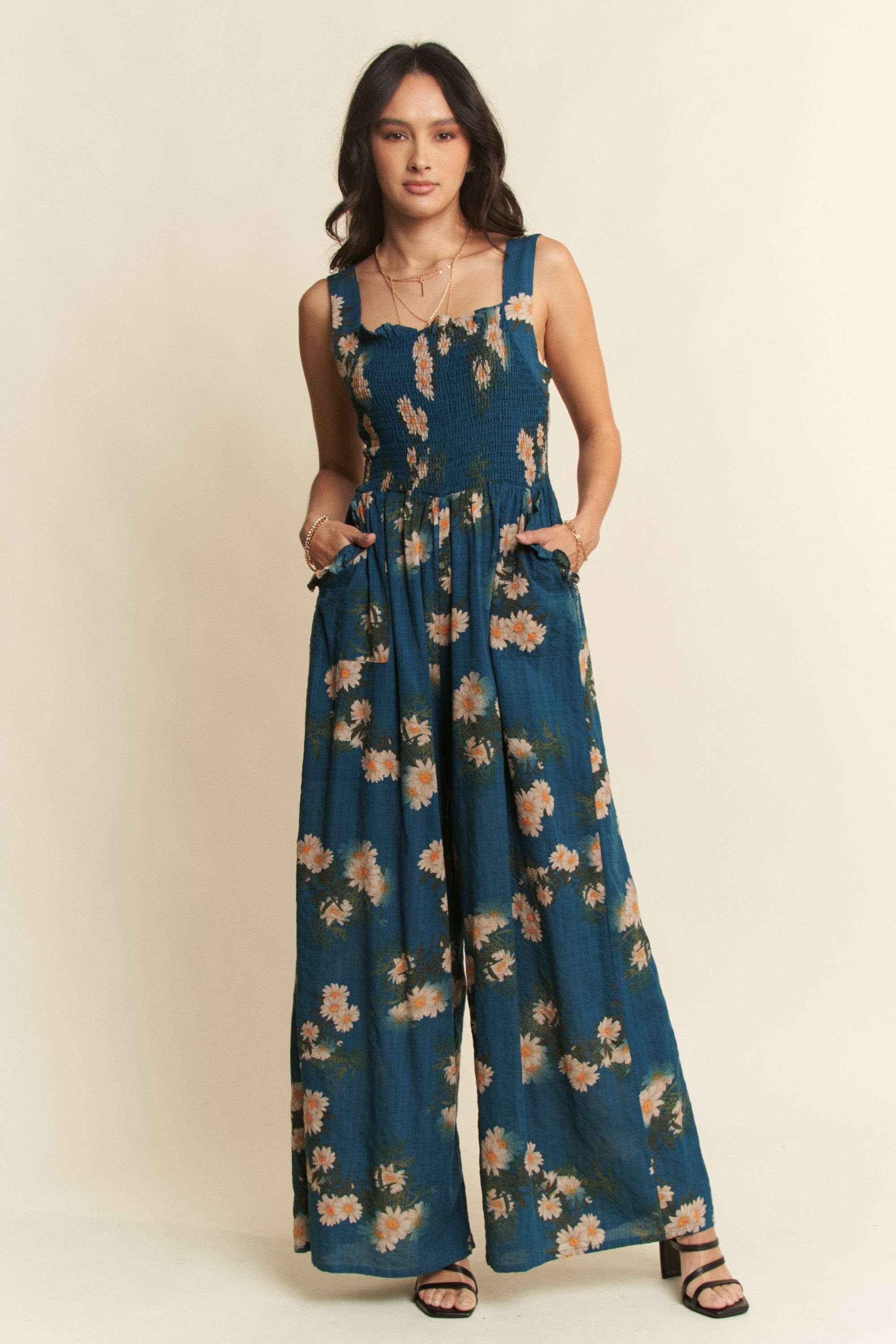 Woman wearing a blue floral jumpsuit on a beige background