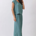 Woman wearing a teal outfit on a white background