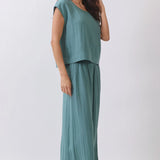 Woman wearing a teal outfit on a white background