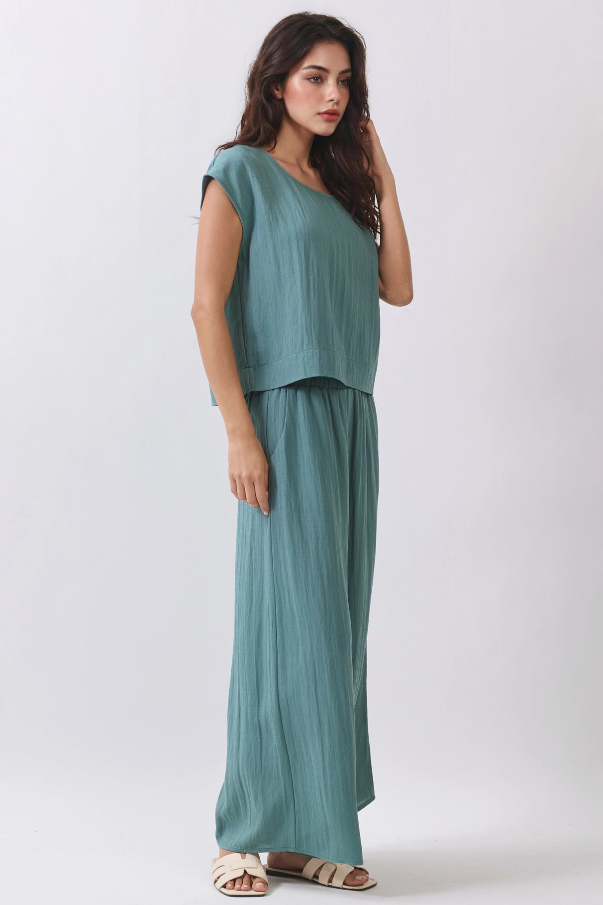 Woman wearing a teal outfit on a white background
