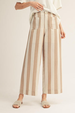 Person wearing beige and white striped pants on a plain background