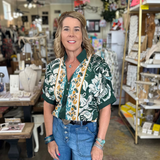 Woman standing in a store with shelves and products in the background