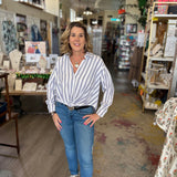 Woman standing in a store wearing a striped shirt and jeans