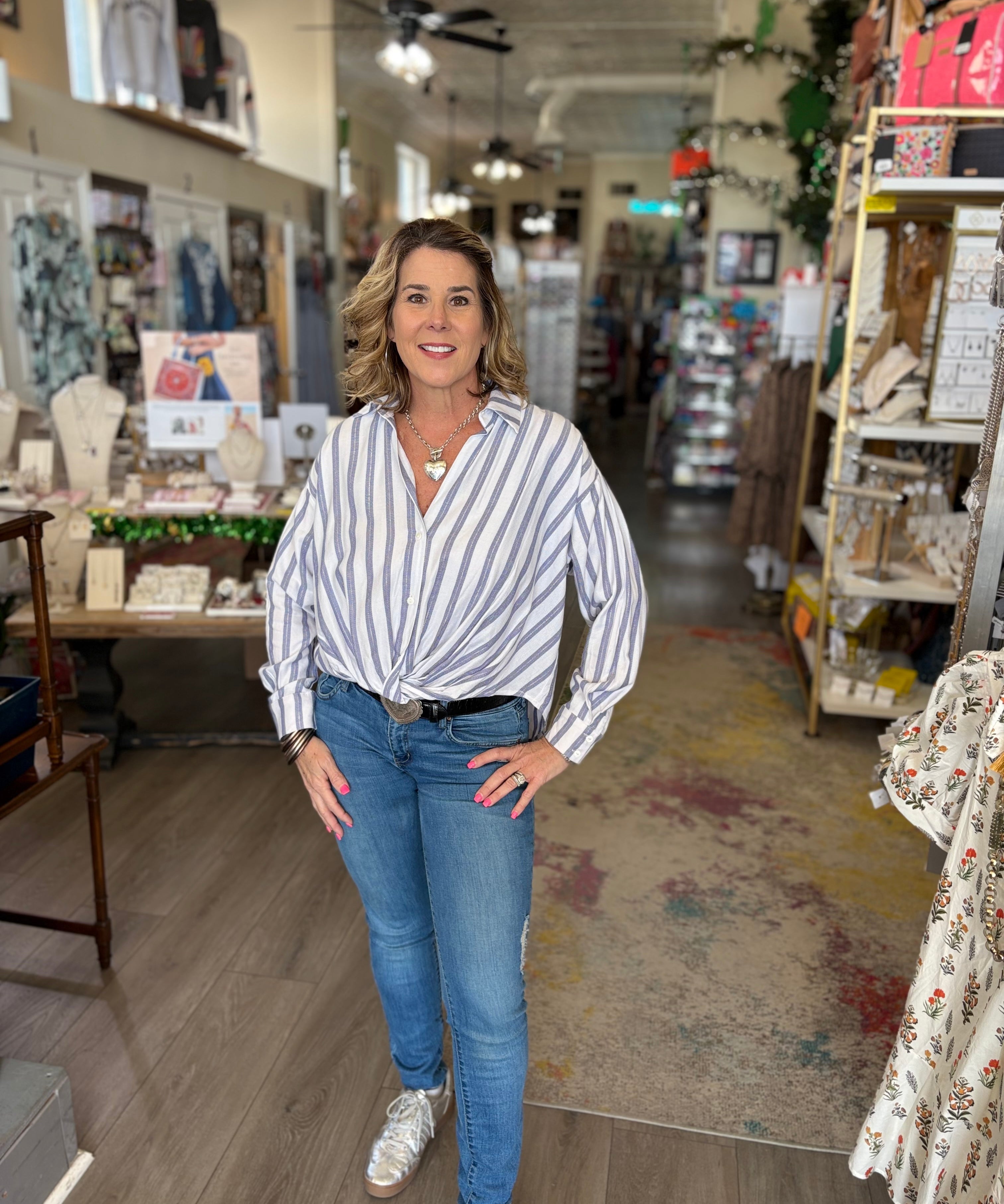 Woman standing in a store wearing a striped shirt and jeans