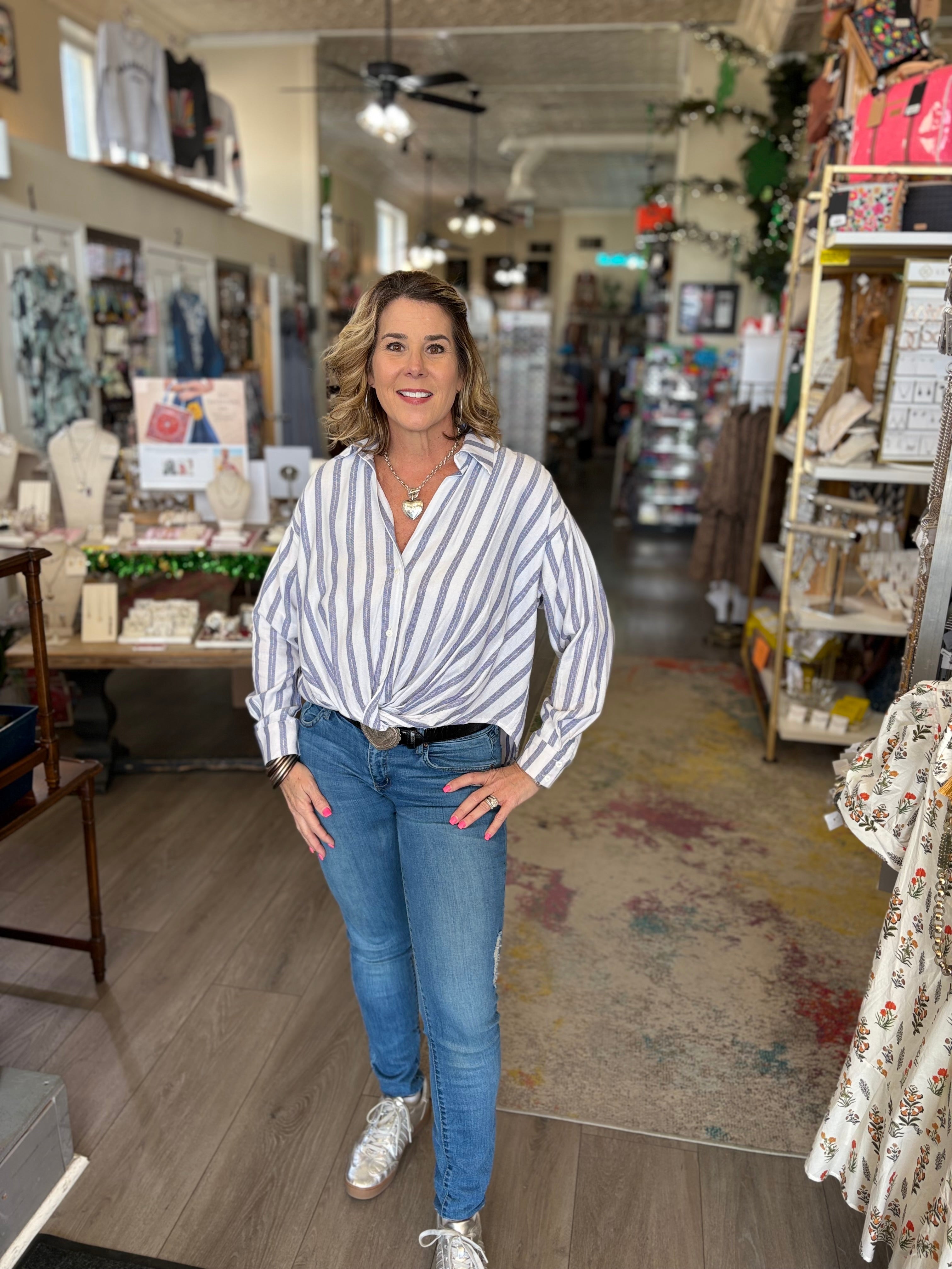 Woman standing in a store wearing a striped shirt and jeans