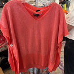 Red sweater on a hanger with a blurred store interior background