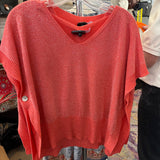 Red sweater on a hanger with a blurred store interior background