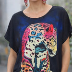 Woman wearing a black t-shirt with a colorful leopard design.