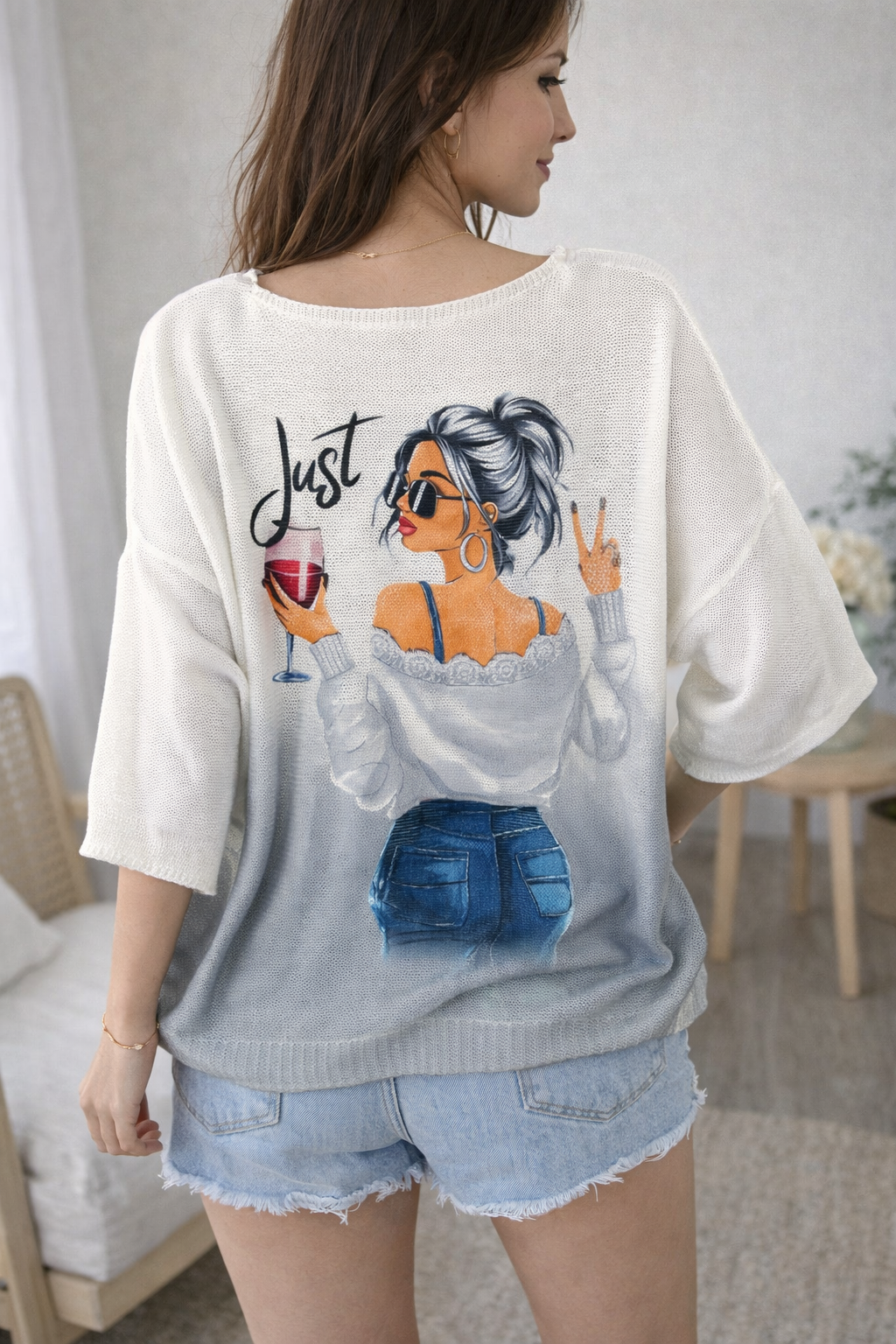 Woman wearing a white t-shirt with a graphic design of a woman holding a glass of wine and sunglasses.