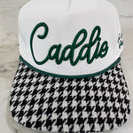 Two golf club heads, one white with green text and the other black and white checkered, on a marble surface.