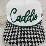 Two golf club heads, one white with green text and the other black and white checkered, on a marble surface.