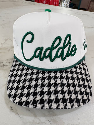 Two golf club heads, one white with green text and the other black and white checkered, on a marble surface.