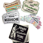 Collection of Waxahachie-themed stickers on a marble surface