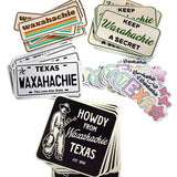 Collection of Waxahachie-themed stickers on a marble surface