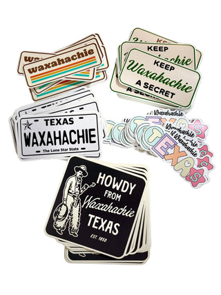 Collection of Waxahachie-themed stickers on a marble surface