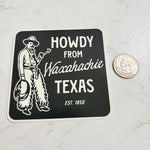 Sticker with 'Howdy from Waxahachie Texas' text and a cowboy graphic on a marble surface.