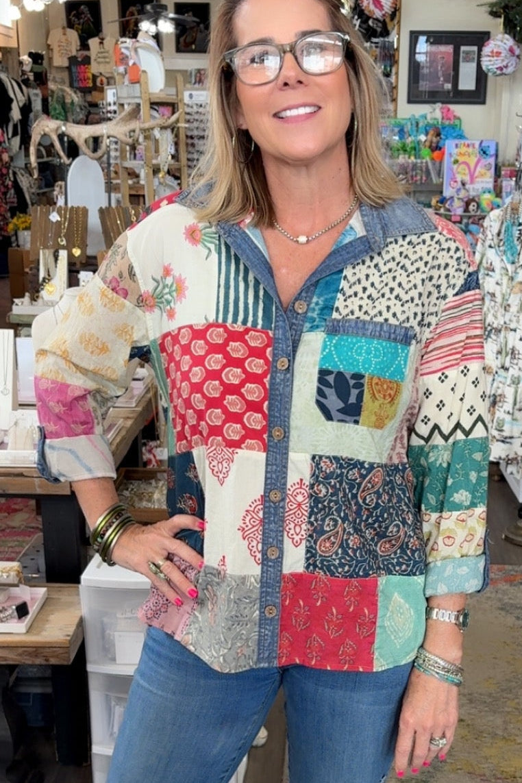 Woman wearing a colorful patchwork shirt in a store setting