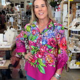 Woman wearing a colorful floral blouse in a store setting