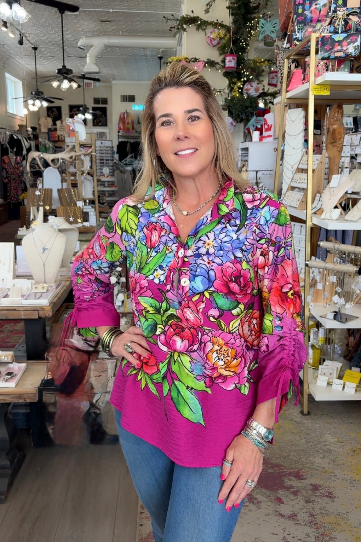 Woman wearing a colorful floral blouse in a store setting