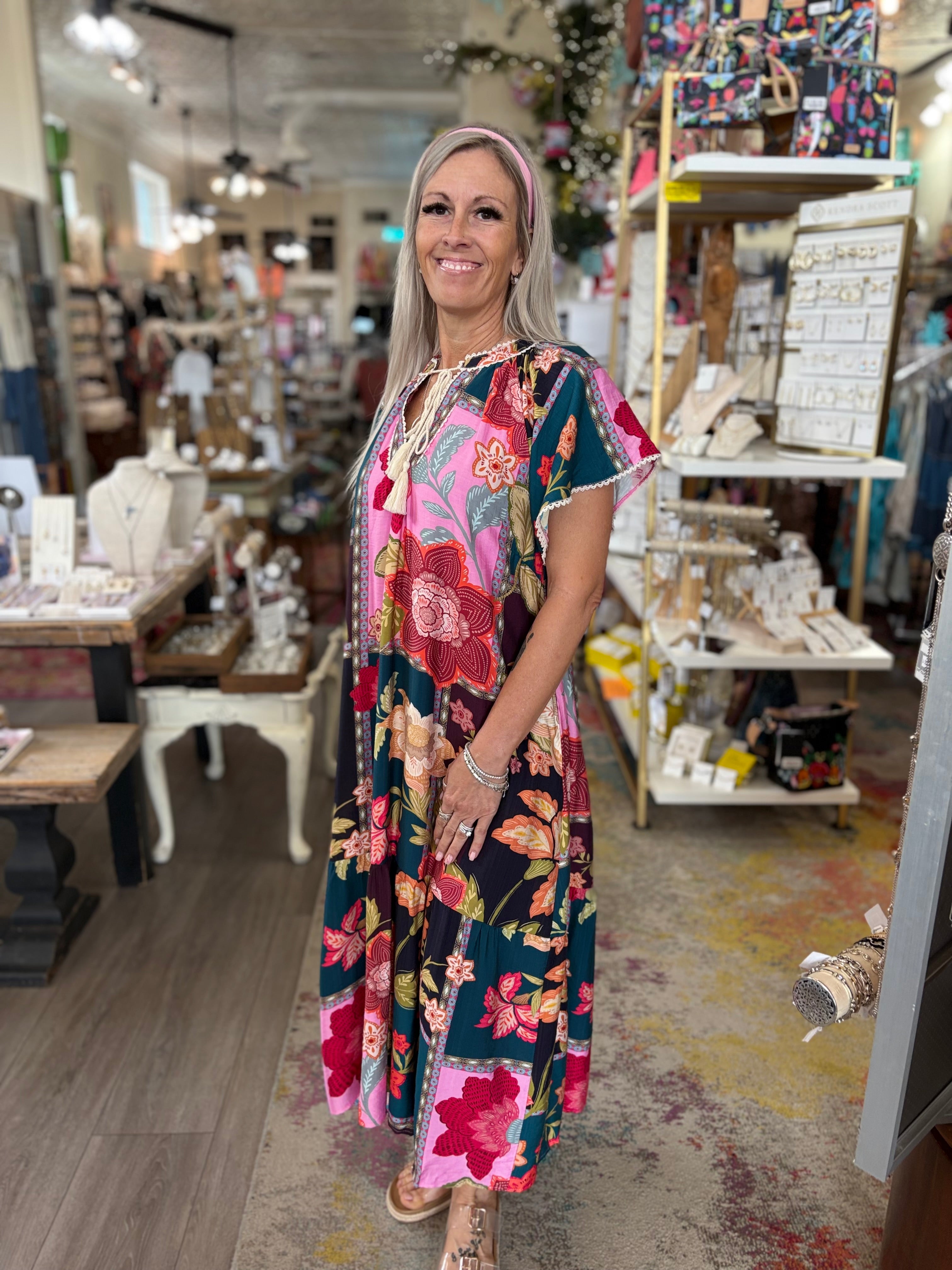 Woman wearing a colorful floral dress in a store setting