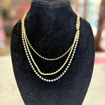 Gold necklace on a black velvet bust with a blurred background