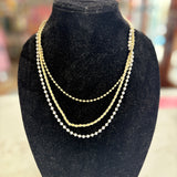 Gold necklace on a black velvet bust with a blurred background