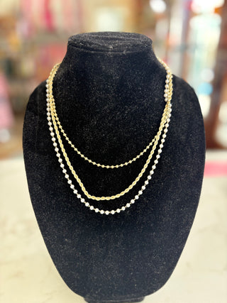 Gold necklace on a black velvet bust with a blurred background