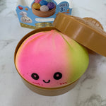 Squishy toy with a smiley face in a brown container on a marble surface