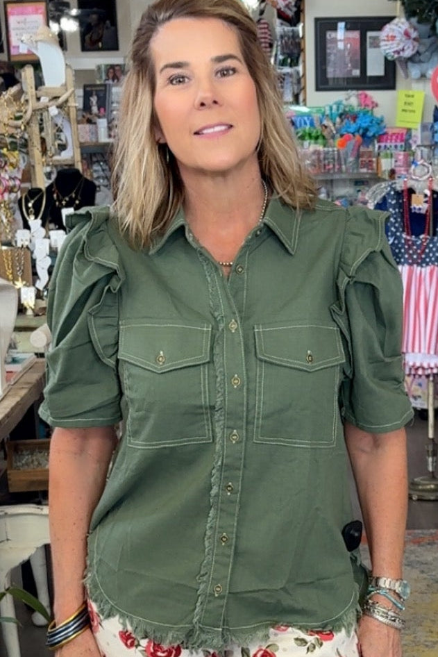 Woman in a store wearing a green shirt and floral pants