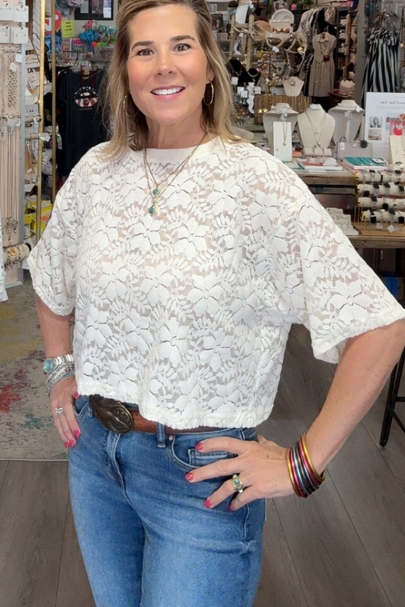 Woman standing in a store with clothing and decor items around her