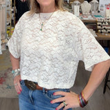 Woman standing in a store with clothing and decor items around her