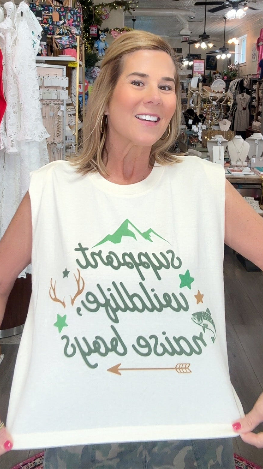 Woman wearing a white tank top with text in a store setting