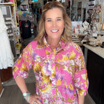 Woman wearing a colorful floral shirt in a store setting
