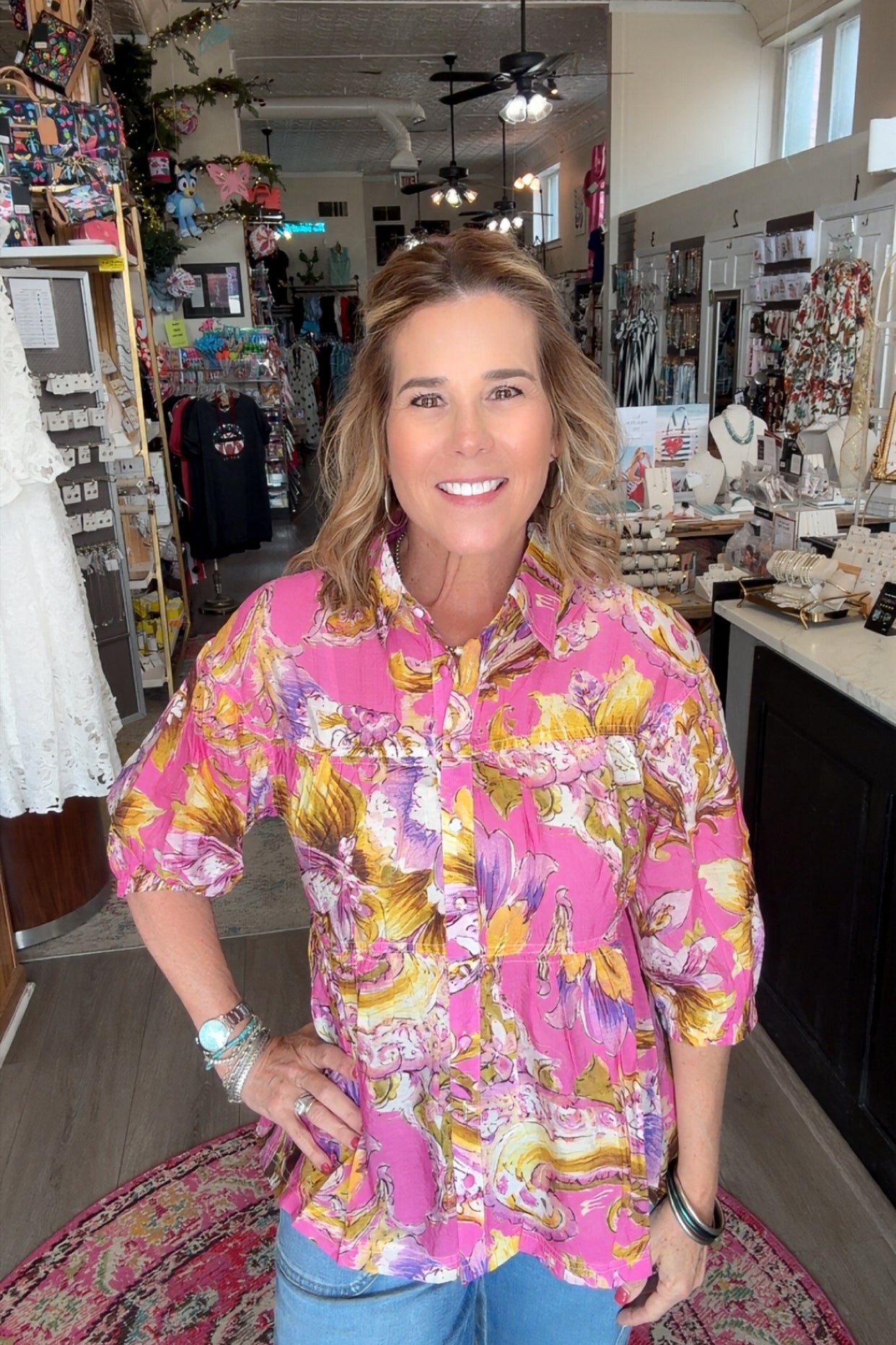 Woman wearing a colorful floral shirt in a store setting