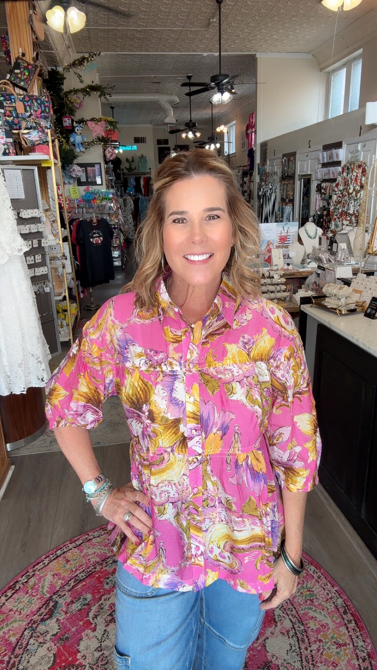 Woman wearing a colorful floral shirt in a store setting