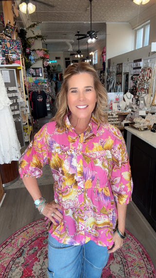 Woman wearing a colorful floral shirt in a store setting