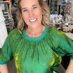 Woman wearing a green top and blue jeans in a store setting